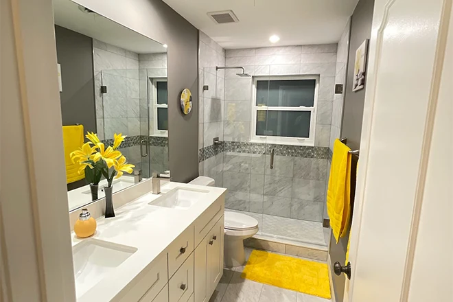 Bathroom with double vanity and stone tiles and glass door walk in shower