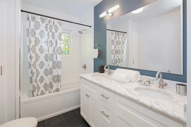 New bathroom with double oval marble sink and shower curtain