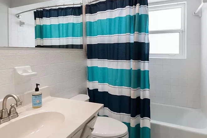 Small bathroom with shower-tub combo and shower curtain