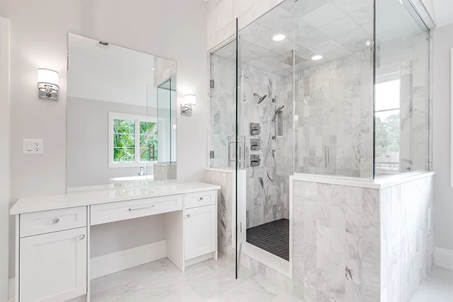 A bright luxury bathroom with a large shower and small white vanity counter top